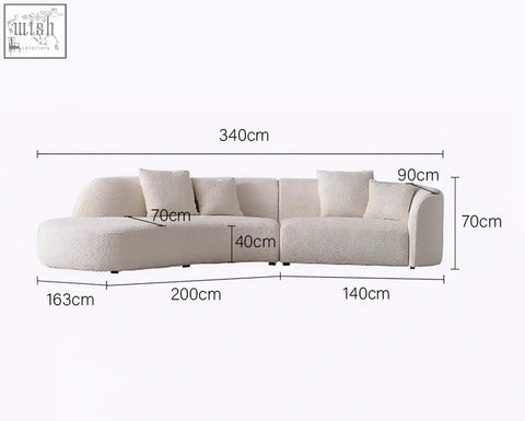Cream-colored plush faux fur three seater sectional sofa with modern l-shaped design and matching pillows goldie gubi three