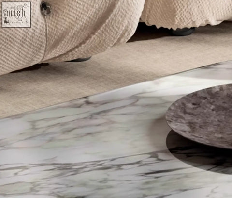 A dark gray textured ceramic plate on white marble surface part of the goliah coffee table set with marble top