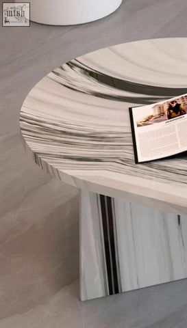 A sleek goliah coffee table set with a round polished white and gray marble top featuring black veining