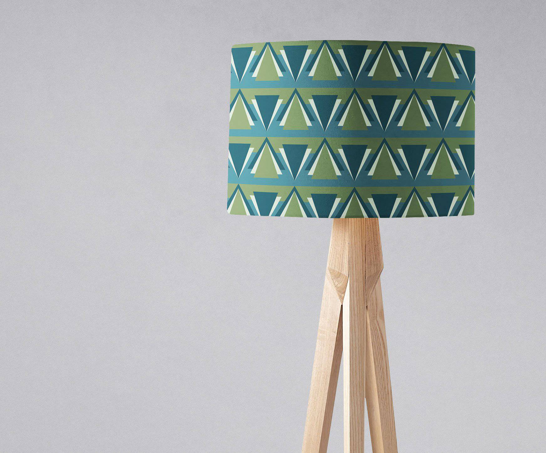 Cylindrical art deco lampshade with teal and olive triangles on a wooden tripod base perfect for a blue art deco table lamp