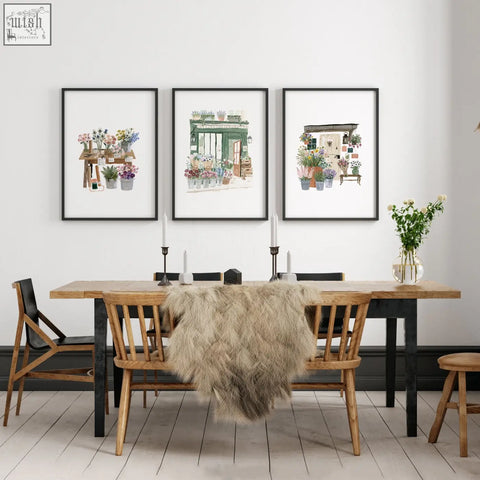 Three framed green art botanical prints hang above a wooden dining room table as decorative wall art prints set of 3