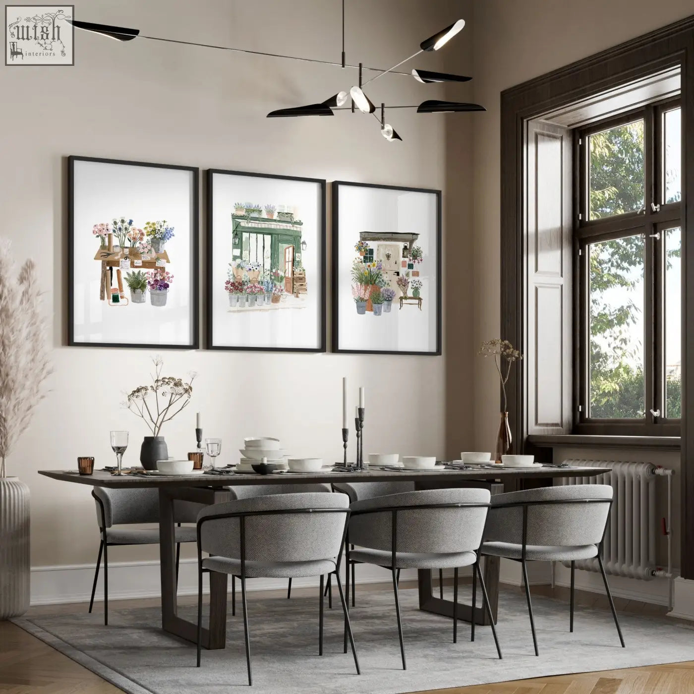 Three green art botanical art prints in black frames hang above a dining room table for cozy wall decor