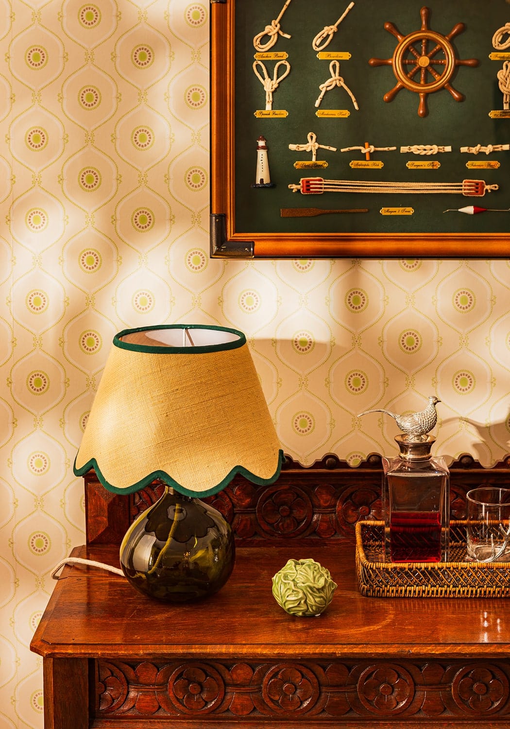 A vintage table lamp with a green petal jute scallop lampshade in mustard yellow and a glossy teardrop glass base