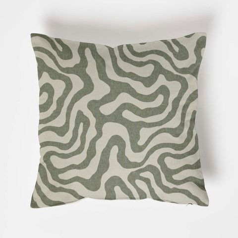 Square green wiggle throw cushion with modern olive green and off-white wavy lines on textured fabric