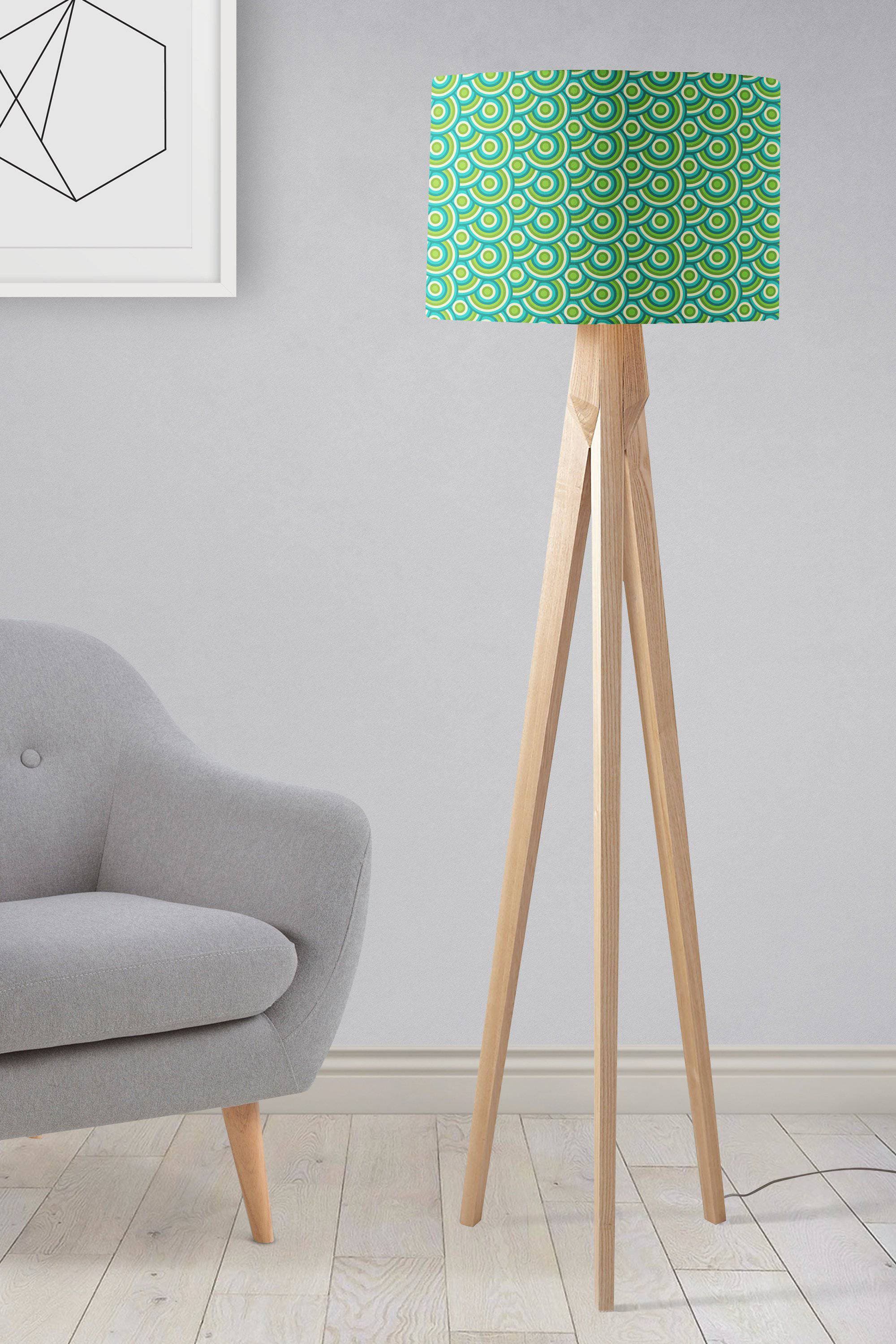 A modern tripod floor lamp with a green 70s retro circles lamp shade and light wood legs perfect as a table lamp shade