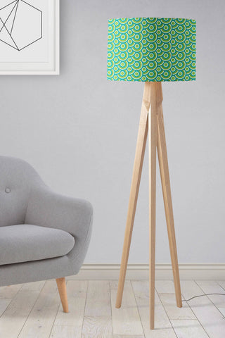 A modern tripod floor lamp with a green 70s retro circles lamp shade and light wood legs perfect as a table lamp shade