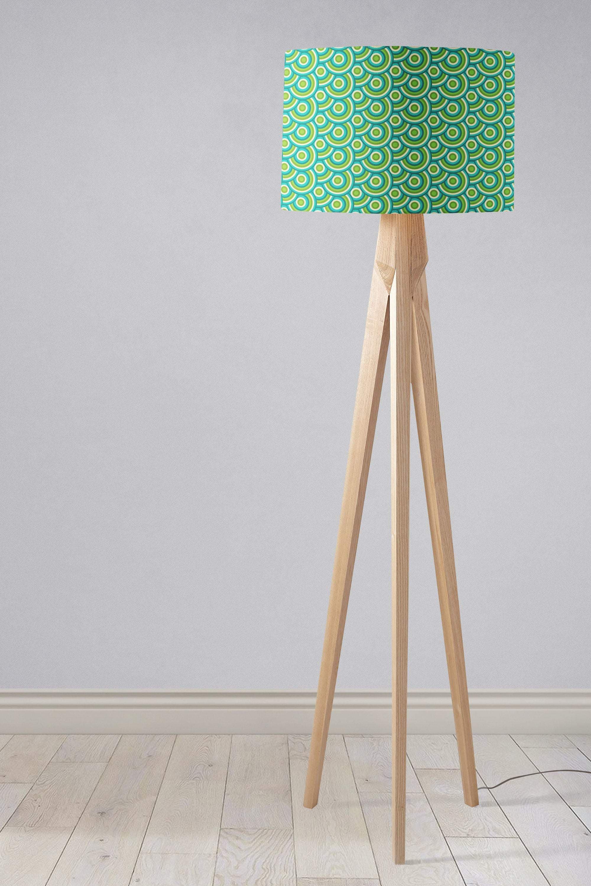 A modern tripod floor lamp with a green 70s retro circles lamp shade and light wood legs perfect as a table lamp with inch diameter