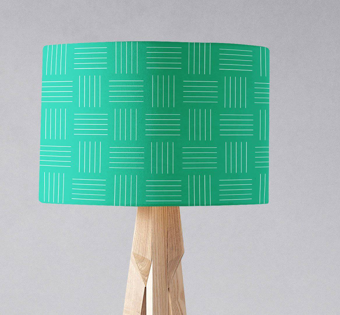 A vibrant teal table lamp shade with white geometric lines on a light wood tripod base inch diameter design