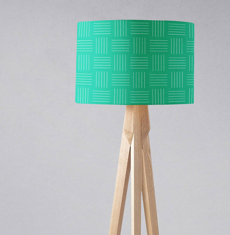 Green table lamp with white lines geometric design lampshade on a light wood tripod base with inch diameter