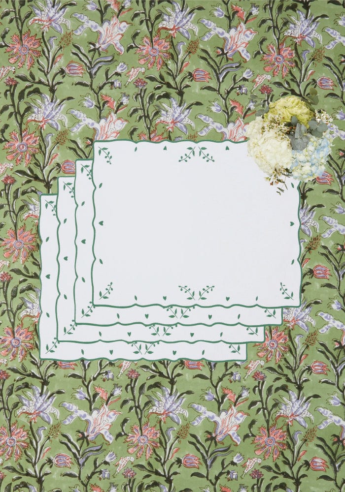 White lace edged placemats with delicate green floral embroidery complement the green with envy floral print tablecloth