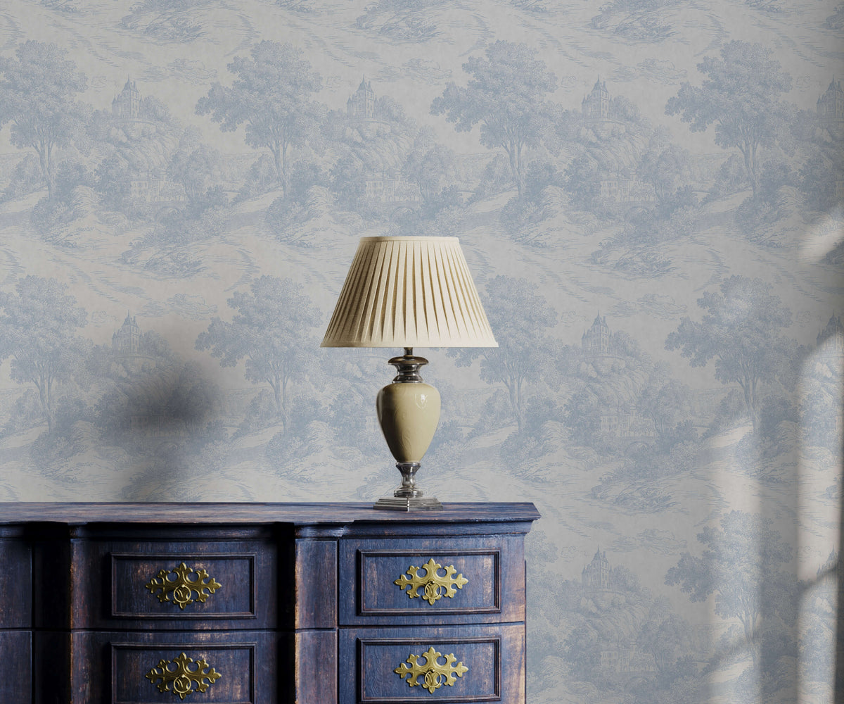 Gregory cream pleated lampshade on ceramic base with metallic accents on antique blue dresser near toile pattern wallpaper
