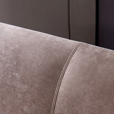 Armrest of a taupe suede greta king size and super king size bed with neat stitching along its curved edge