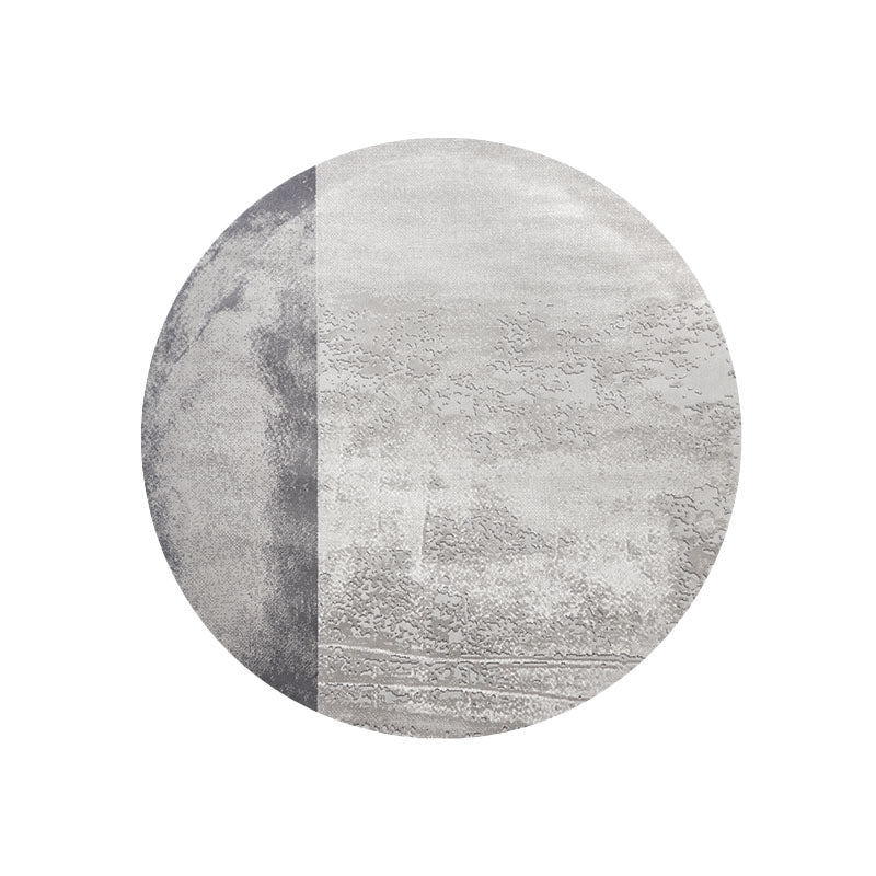 Circular grey and white moon rug with textured split pattern in charcoal and silver gray featuring abstract landscape designs
