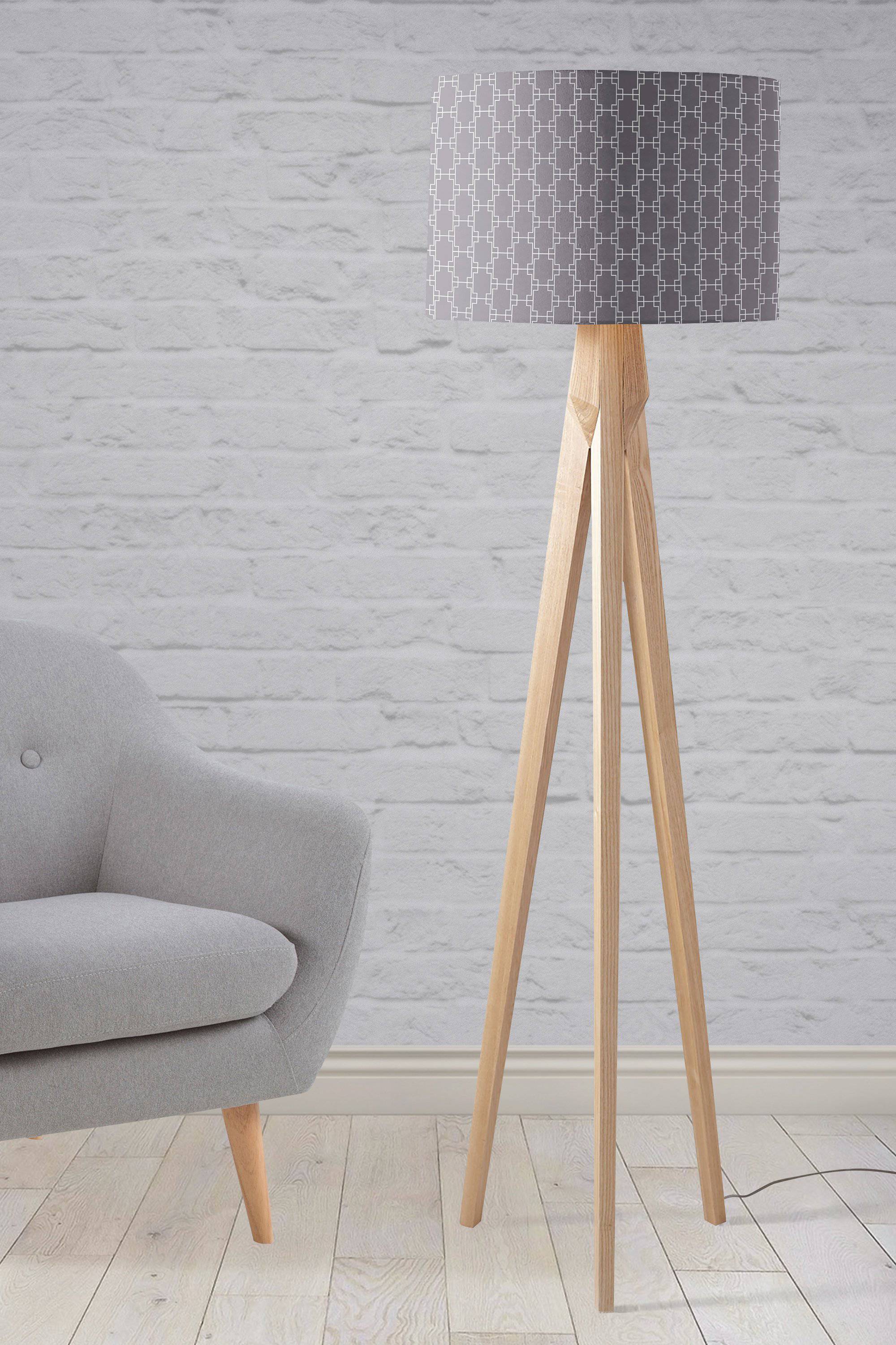 A modern table lamp with a grey fabric shade featuring white squares geometric design and light wood legs, inch diameter