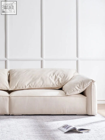 Cream-colored leather grimm three seater sofa with plush cushioned seating and clean modern lines perfect for living rooms