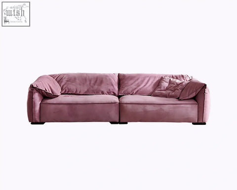 A grimm three seater sofa in dusty rose velvet with modern design and matching throw pillows perfect for living rooms