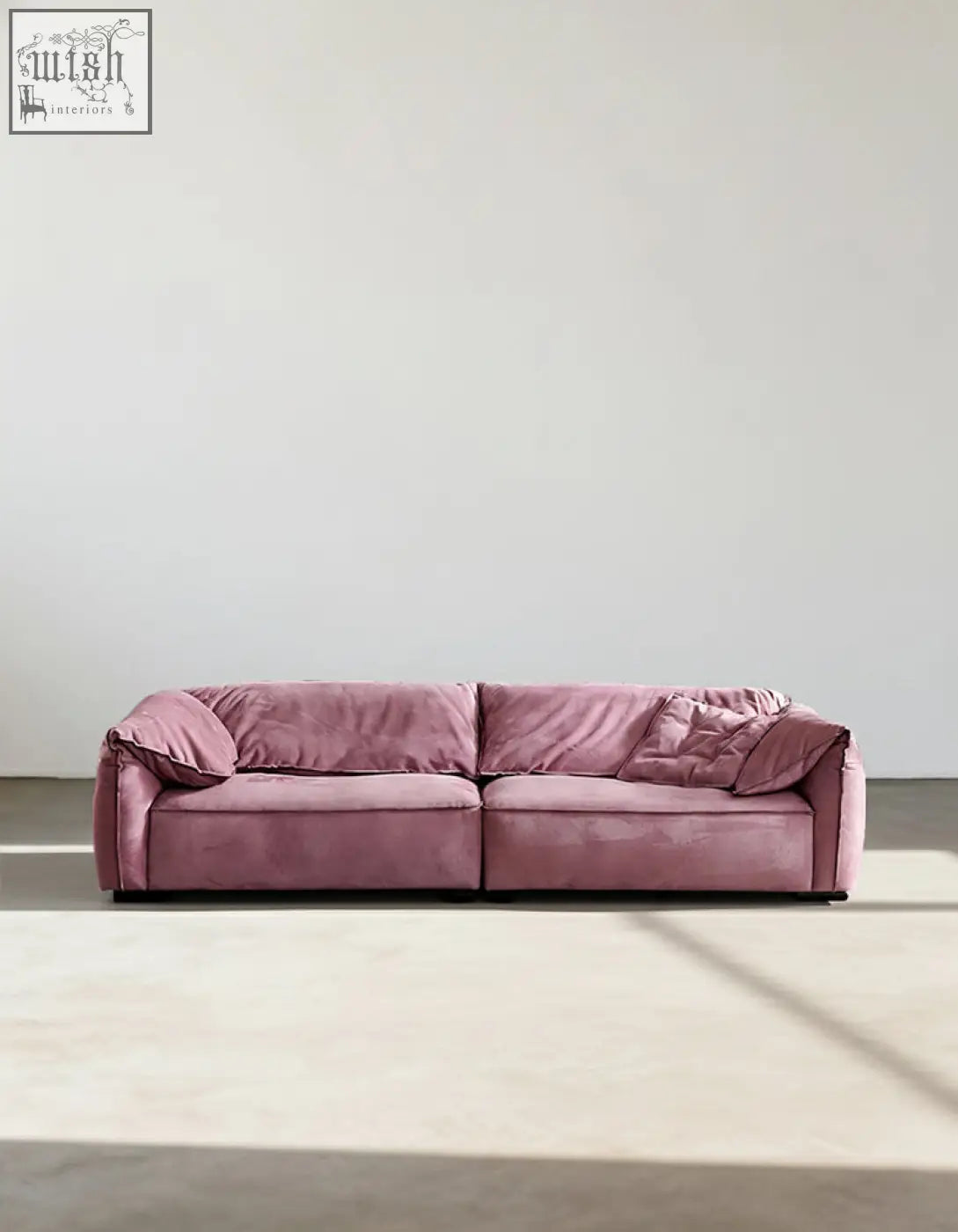 A plush dusty rose grimm velvet sofa with modern low-profile design and soft rounded armrests that seamlessly blends style