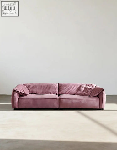 A plush dusty rose grimm velvet sofa with modern low-profile design and soft rounded armrests that seamlessly blends style