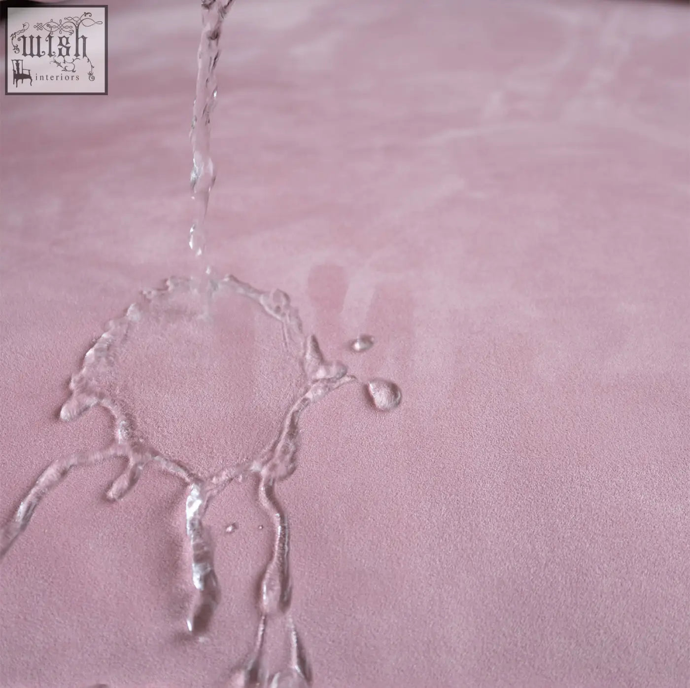 A soft pink suede surface with water droplets on the grimm velvet sofa that seamlessly blends style and comfort