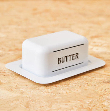 White metal butter dish with matching tray and black butter lettering made of ceramic and metal