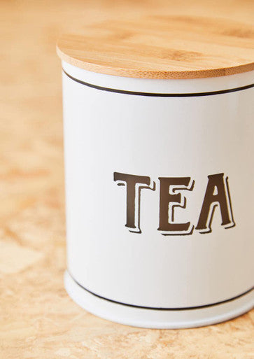 White metal tea canister with a natural bamboo lid and black lettering for stylish kitchen storage