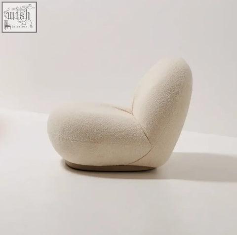Cream-colored gubi pacha chair with plush boucle upholstery and gold base perfect as a stylish accent chair
