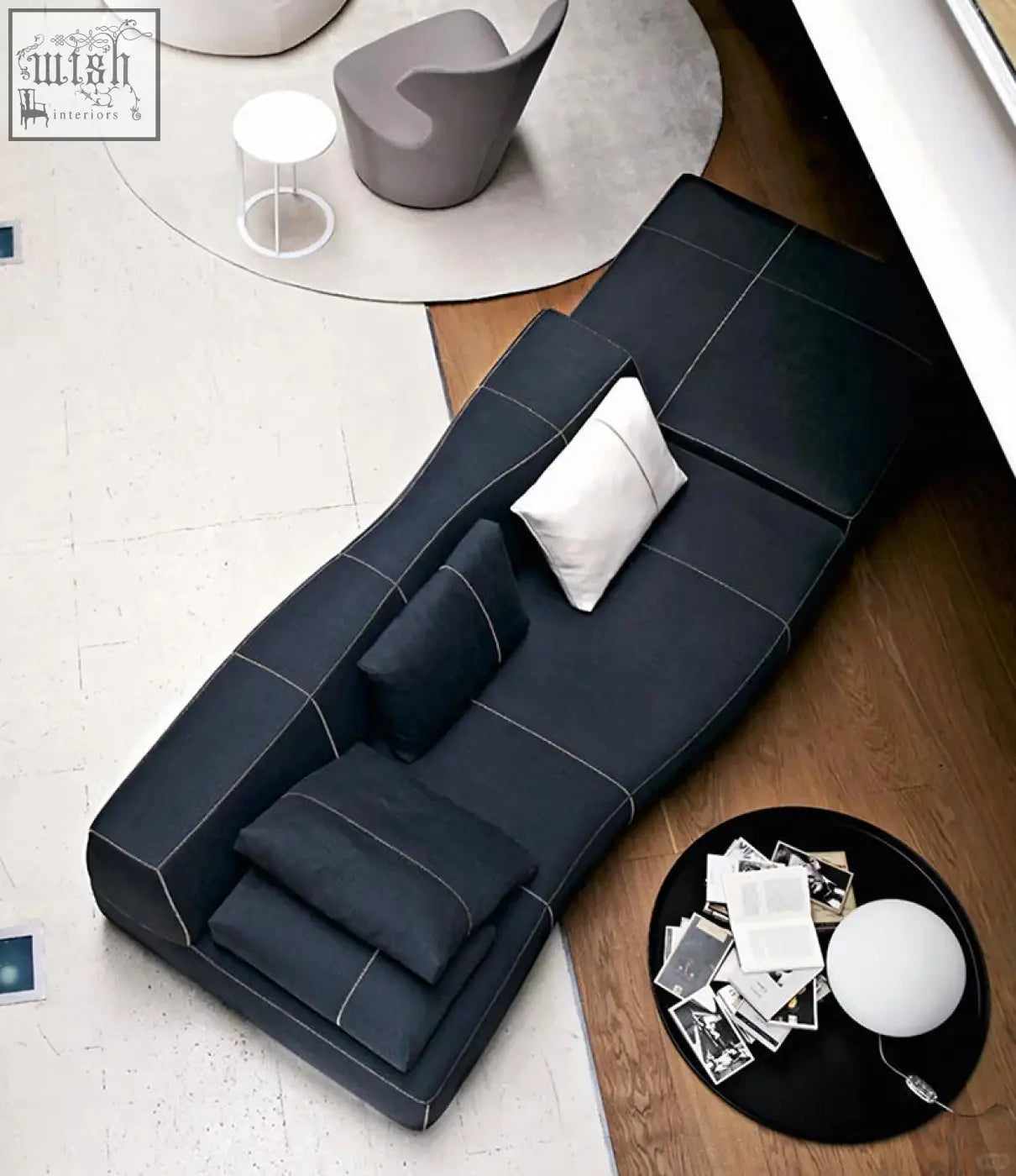 Black guzman velvet corner sofa with white stitching and dark cushions in a stylish velvet corner sofa design