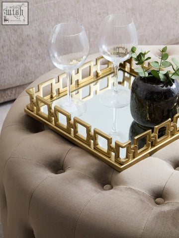 Gold-framed rectangular mirror tray with geometric border design displayed on a mink velvet round tufted footstool
