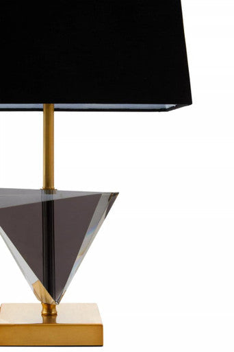A halina smoked crystal table lamp features a sleek black shade on a gold metal base with a clear faceted prism stand