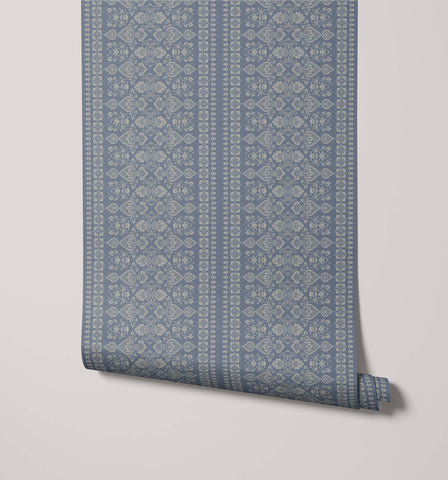 A roll of hallen blue damask floral stripe wallpaper with an intricate repeating pattern in a lighter shade