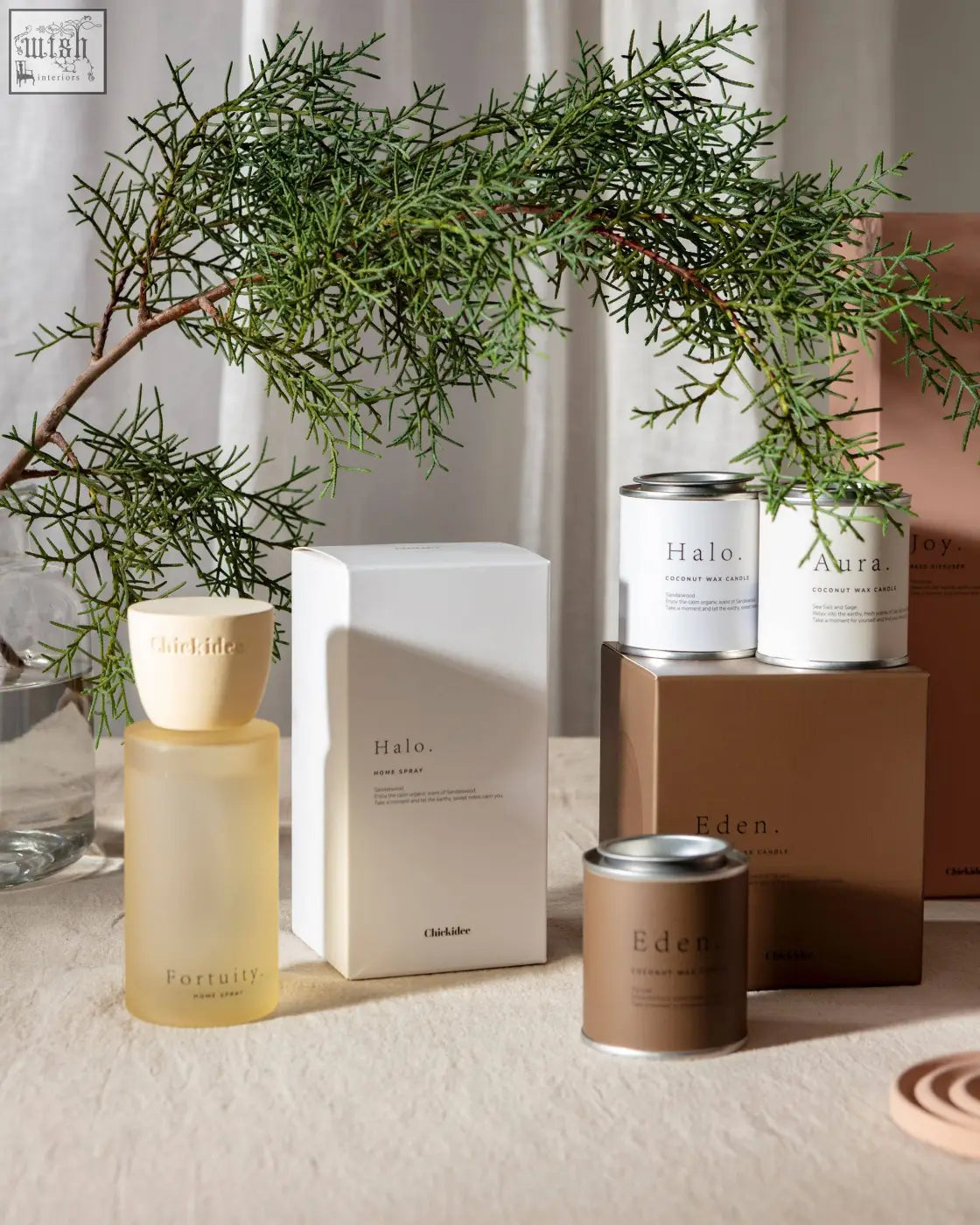 A tall slender halo clay home spray bottle with a warm base amber glass body and matte beige cap