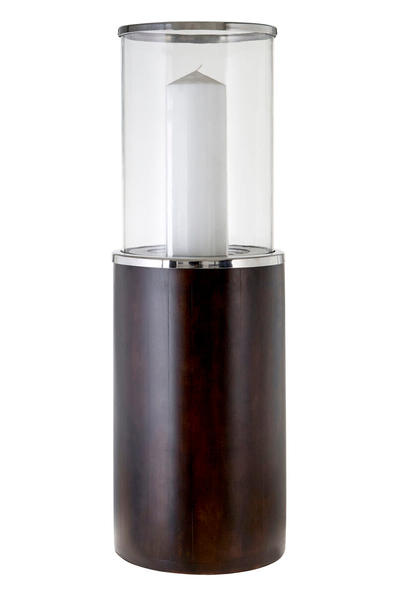 A sleek hampstead large mango wood hurricane candle holder with a dark wood base and white pillar candle inside clear glass