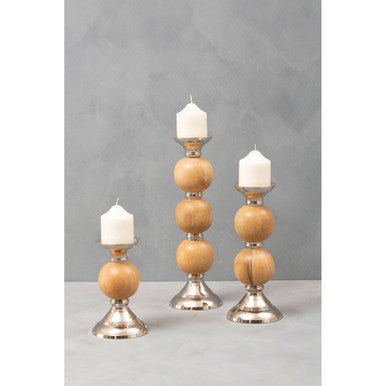Set of three hampstead medium pillar candle holders with wooden balls and silver metal bases holding white taper candles