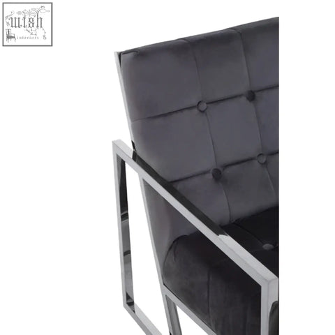 Black tufted velvet armchair with sleek stainless steel frame perfect for stylish living spaces