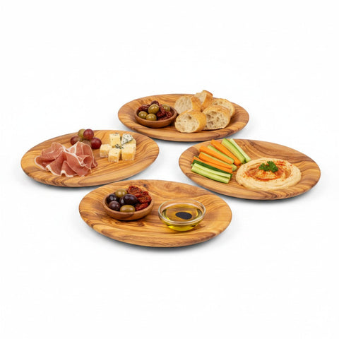 Set of four handcrafted olive wood round plates with natural grain and warm brown tones for tapas in working days