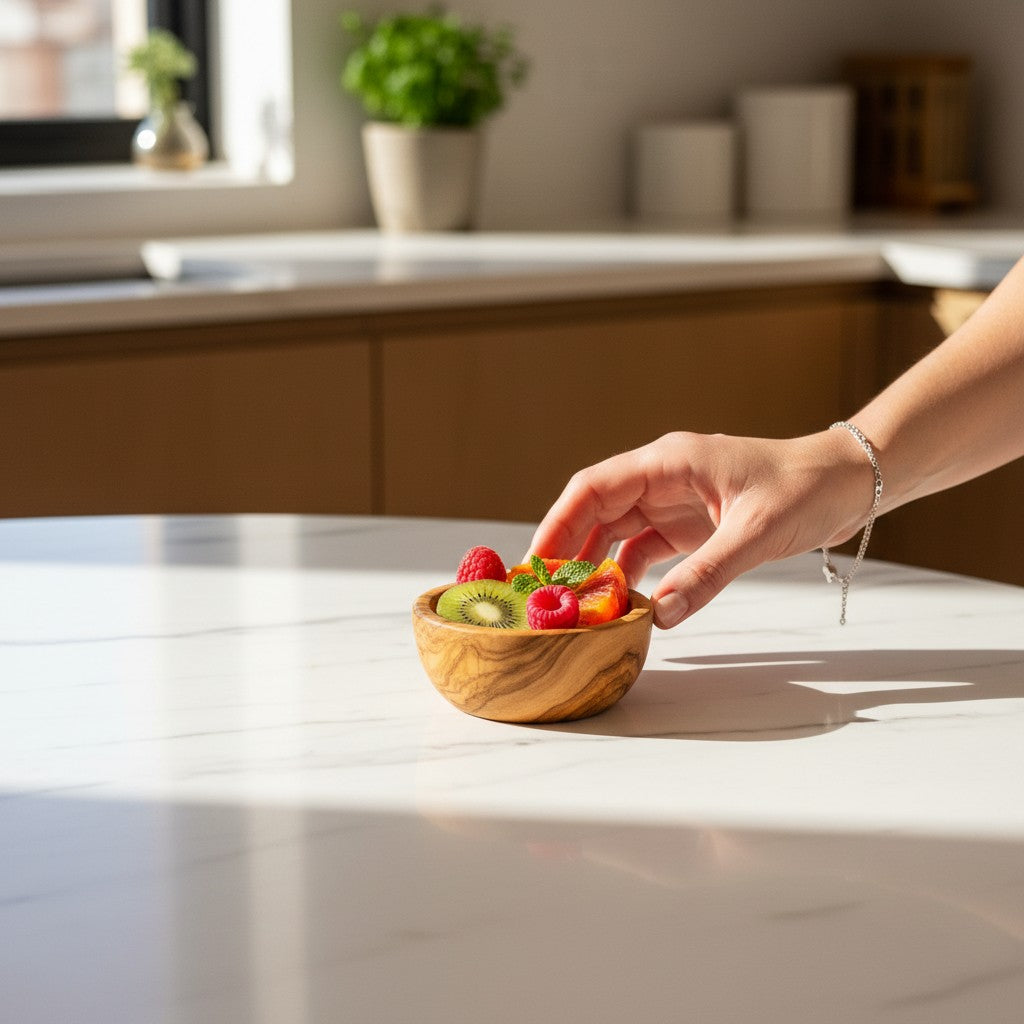 Handmade olive wood bowl with swirling natural grain and silky polished interior filled with fruit slices and mint