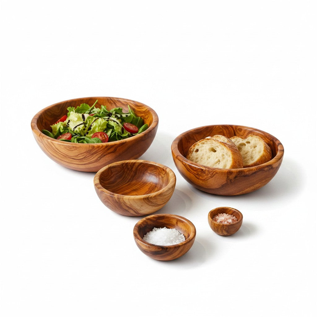 Set of four handmade olive wood bowls with silky polished interior and natural grain for serving salads bread and salt