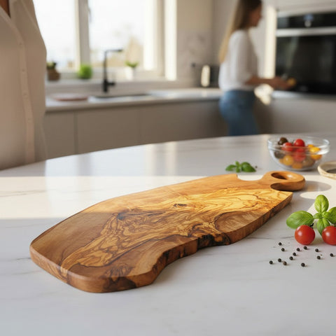 Handmade olive wood serving board with round loop handle rich warm brown finish and unique swirling grain patterns