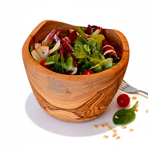 Handcrafted olive wood salad bowl with natural bark edge and warm swirling grain perfect for serving in working days