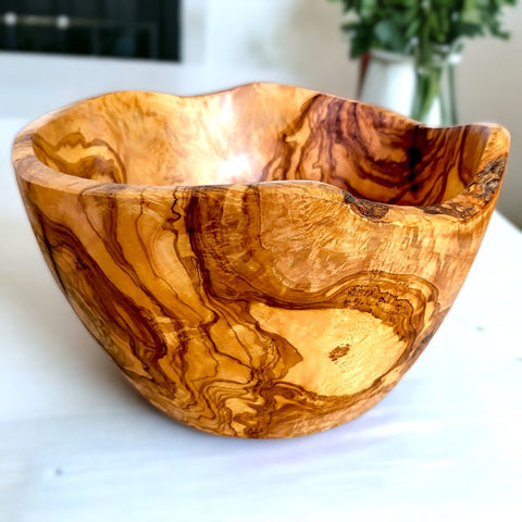 Handmade olive wood live edge salad bowl with unique natural bark edge in golden amber and deep brown tones