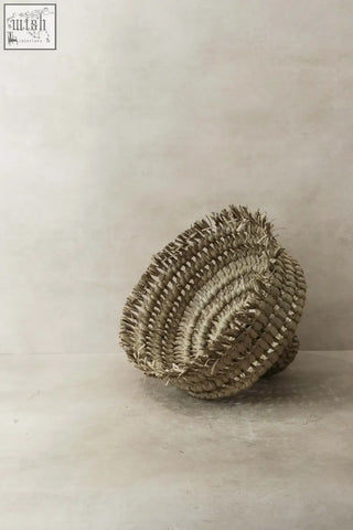 Handwoven beige ilala palm lamp shade with textured circular pattern and frayed edges from mozambique