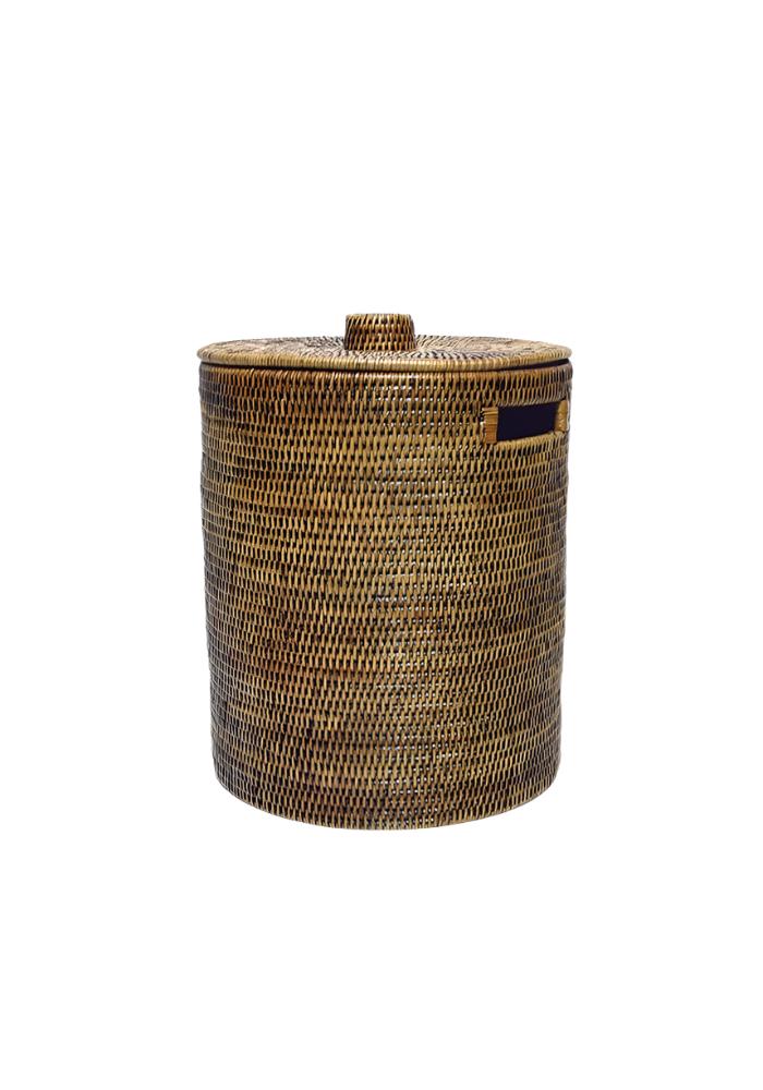 Handwoven luxe washing hamper made of rattan with matching lid and dark blue fabric handle accent