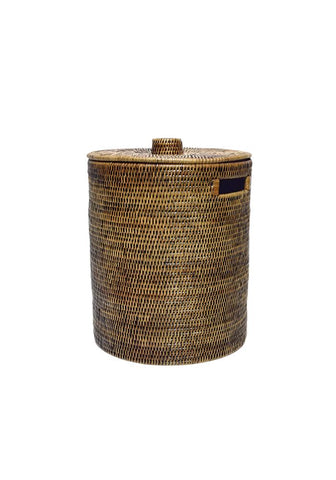 Handwoven luxe washing hamper made of rattan with matching lid and dark blue fabric handle accent