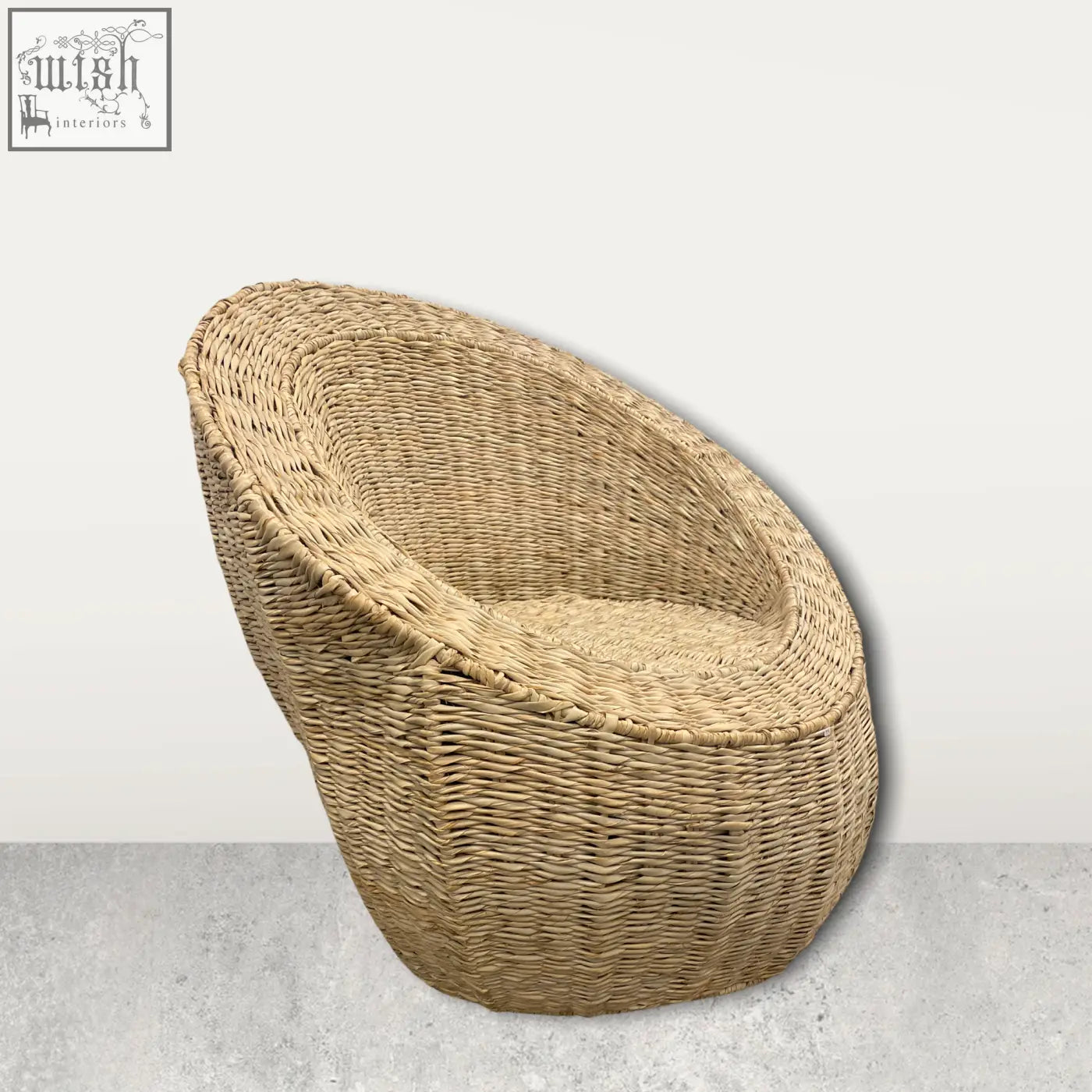 Beige woven rattan palm leaf chair with rounded cozy design perfect for relaxed seating in mozambique style