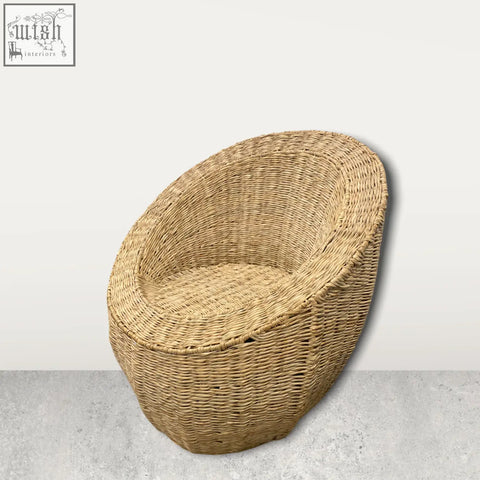 Natural woven palm leaf chair in light beige with a rounded cozy shape handwoven in mozambique
