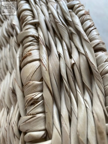 Close-up of handwoven sun chair made from light beige natural fibers showing texture and slight imperfections