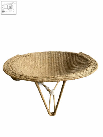 Natural woven wicker bowl with three slender legs paired with handwoven sun chair from mozambique