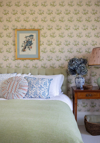 A sage green upholstered tufted headboard with soft texture and vertical stitching for a cozy bedroom look