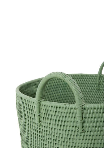 A sage green handy handwoven rattan basket with a textured interlaced pattern and sturdy handles