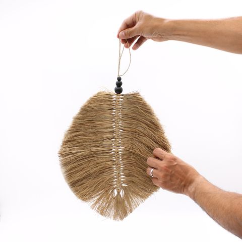 A natural-bristle fan brush with a black beaded handle for grooming in the hanging raffa leaf 35cm design